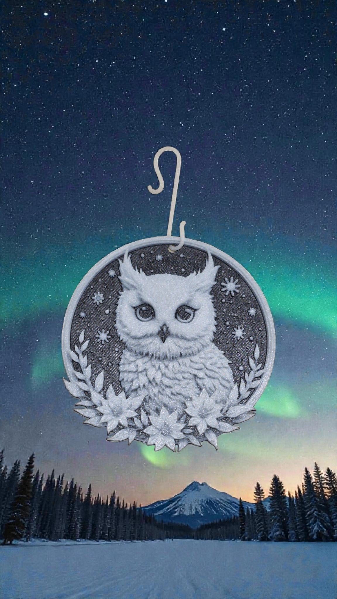 Mystischer 3D-gedruckter Christbaum-Anhänger "Schneeeule" vor einer winterlichen Berglandschaft mit Nordlicht-Himmel.