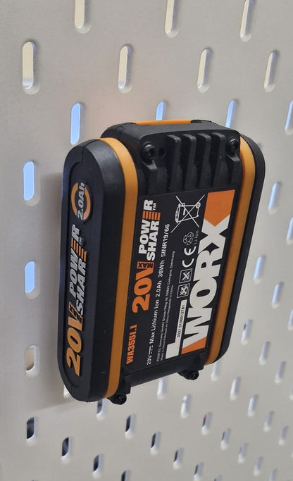Professionelles Foto, das einen Worx 20V Akku sicher montiert in der weißen BTE Deutschland Halterung vor einem weichen Blau-Orange-Farbverlauf zeigt, mit scharfer Fokussierung auf die Akku-Beschriftungen und die Befestigung.