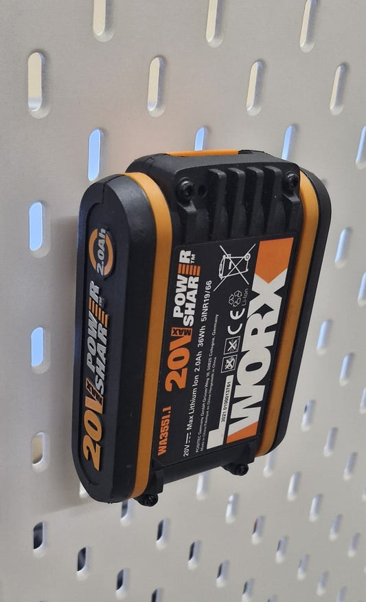 Professionelles Foto, das einen Worx 20V Akku sicher montiert in der weißen BTE Deutschland Halterung vor einem weichen Blau-Orange-Farbverlauf zeigt, mit scharfer Fokussierung auf die Akku-Beschriftungen und die Befestigung.